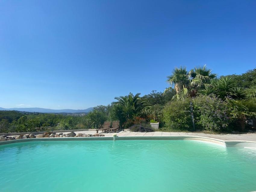une grande piscine d'eau avec une plage et des palmiers dans l'établissement Arts&Sens, à Antibes