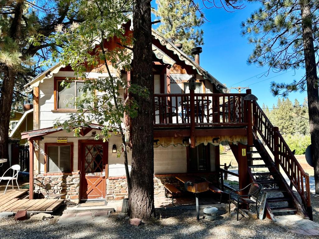 a house with a deck and a tree at Big Bear Lake - Tulip Lane Cabin #22 in Big Bear Lake