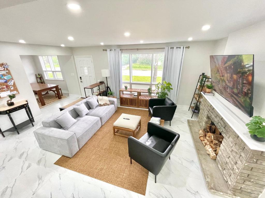 a living room with a couch and a fireplace at New 3 Bedroom Bungalow Ground Floor with BBQ Patio in Richmond Hill