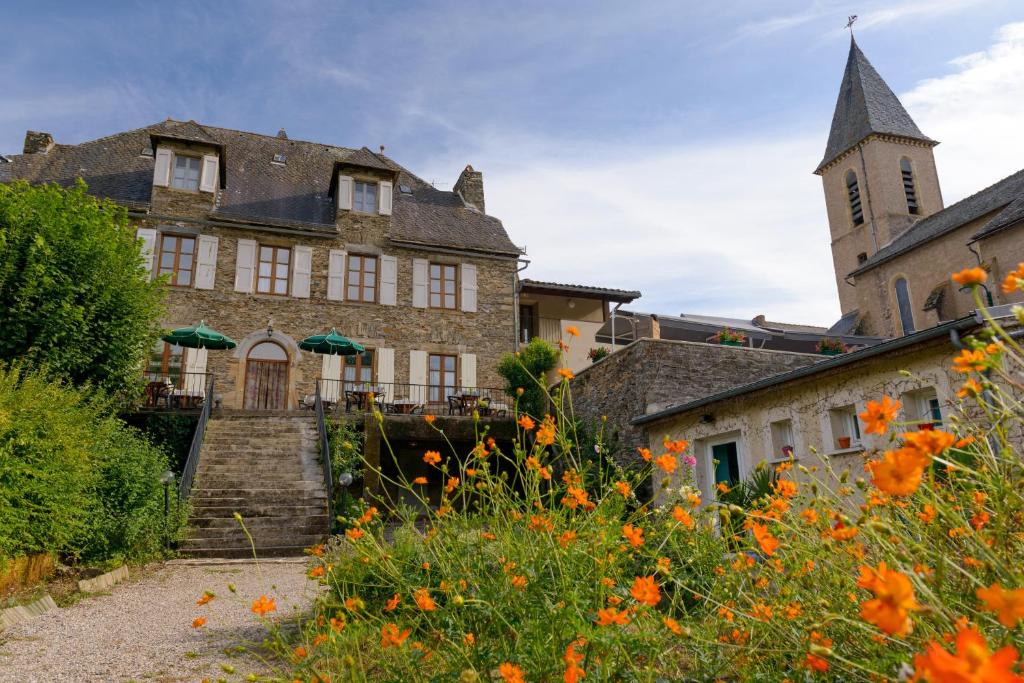 un antiguo edificio de piedra con una torre en Logis Hôtels - Hostellerie des Lauriers - Hôtel et Restaurant en Alban