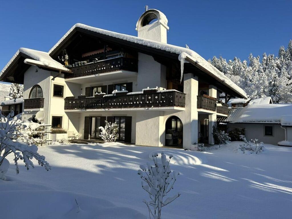 una grande casa con la neve per terra di Pure Mountain Partenkirchen NEU seit 2024 a Garmisch-Partenkirchen
