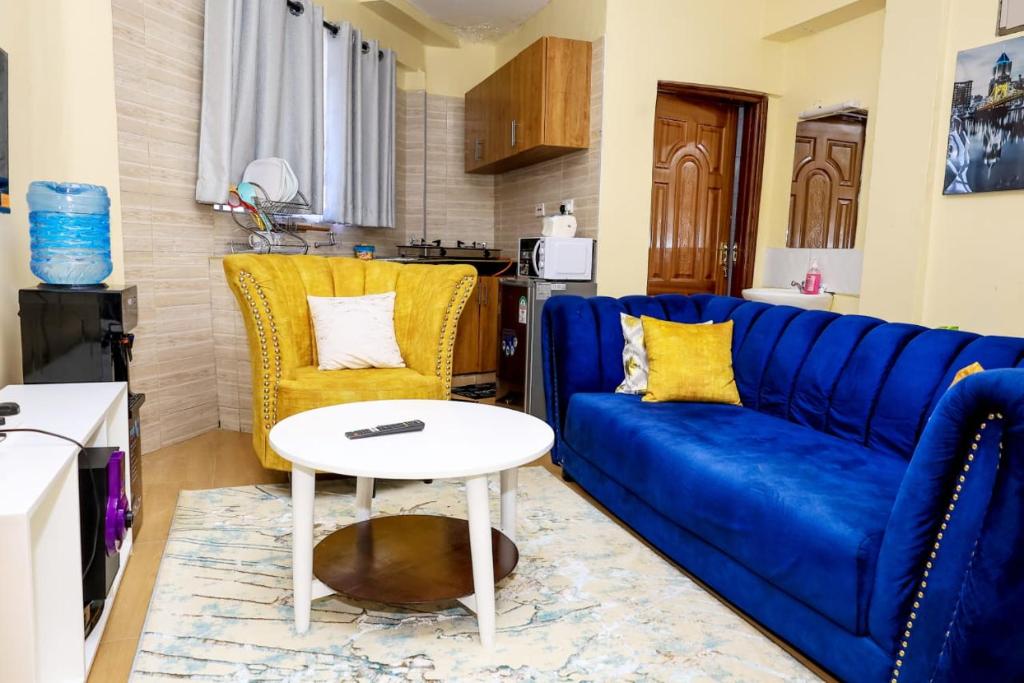 a living room with a blue couch and a table at Studio Apartment, Kisii in Kisii