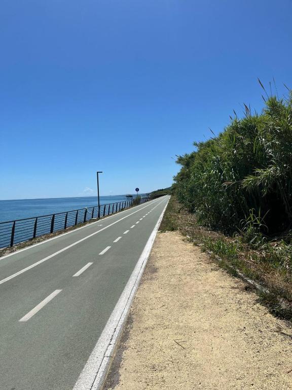an empty road next to the ocean with the horizon at Camasileo in Ortona