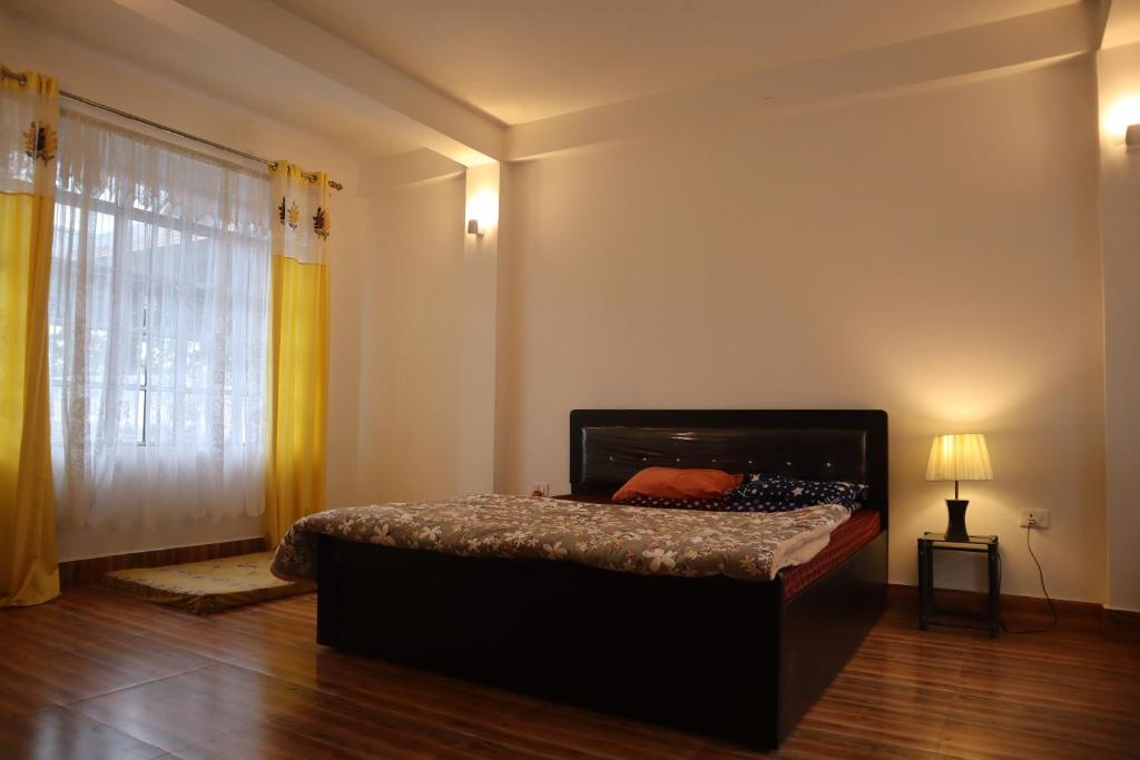 カリンポンにあるThe Scarlett Homestayのベッドと大きな窓のある寝室