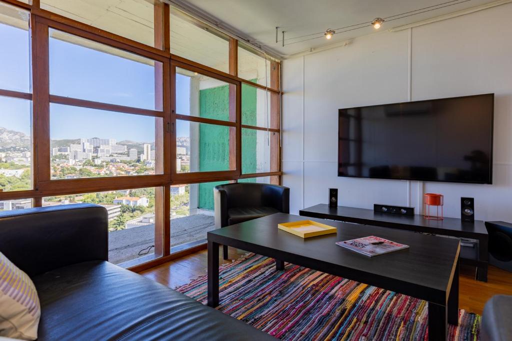 - un salon avec une table et une grande télévision dans l'établissement Superbe Duplex, Magnifique vue, à Marseille