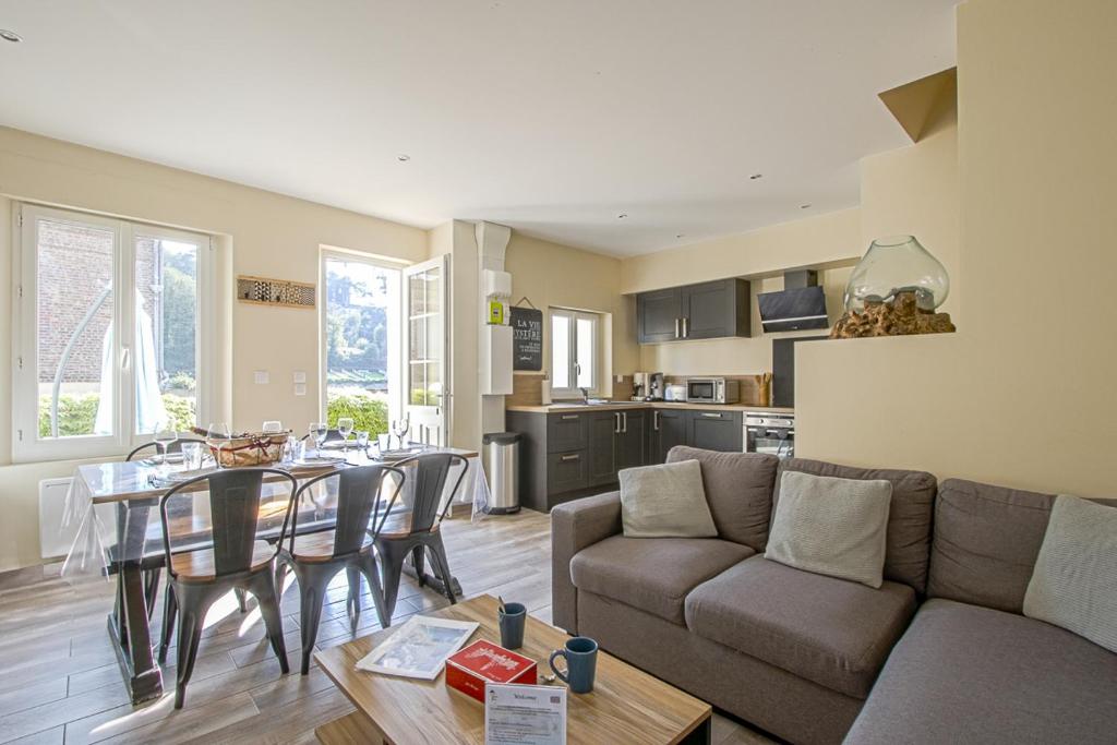 un salon avec un canapé et une table avec des chaises dans l'établissement La Cabane de Plage, à Étretat