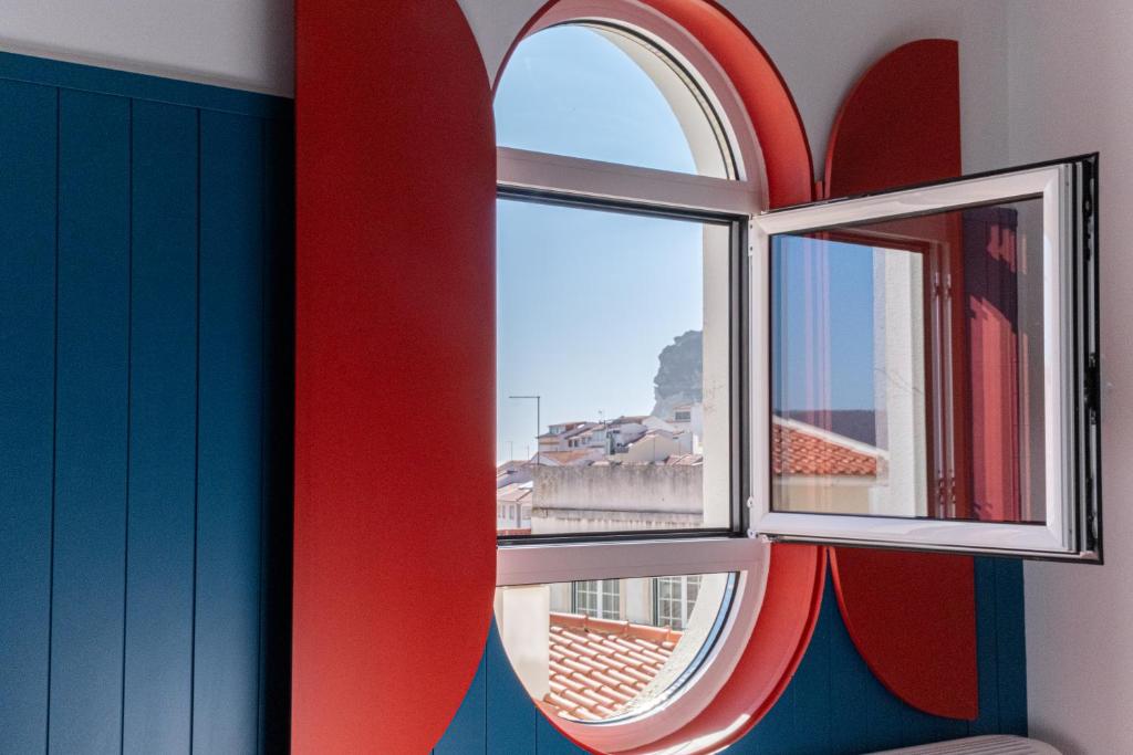 a room with a window with a view of a city at Feel Nazaré - Boat House in Nazaré