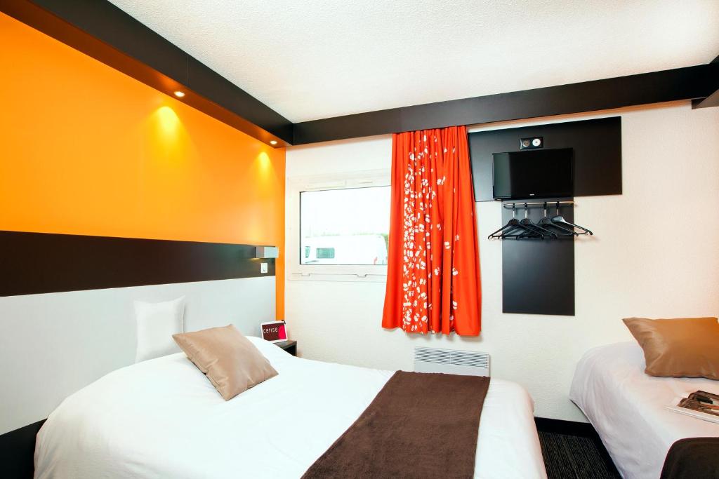 ノイエル・ゴドーにあるHotel Cerise Lensのベッド2台と窓が備わるホテルルームです。