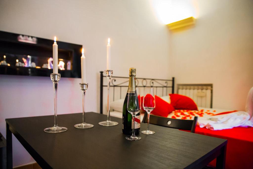 a table with a bottle of wine and three wine glasses at Campo De Fiori Apartment in Rome