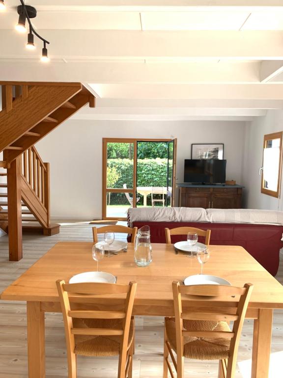 une salle à manger avec une table et des chaises en bois dans l'établissement Dépendance bord de mer, à Plozévet