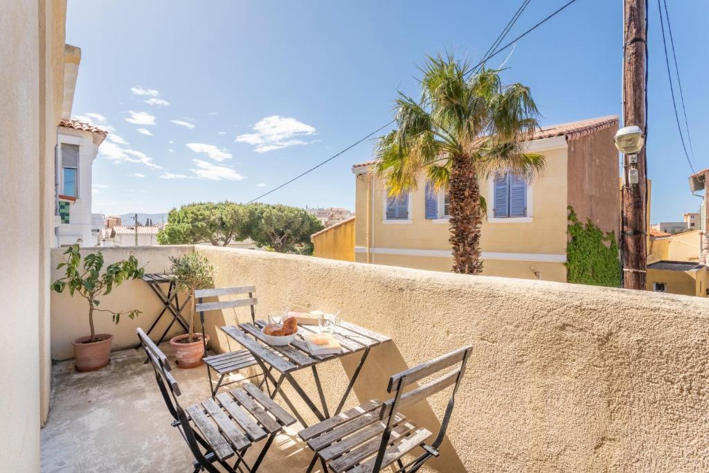 a patio with a table and chairs on a balcony at T2 avec balcon à Malmousque - Calme & vue mer in Marseille