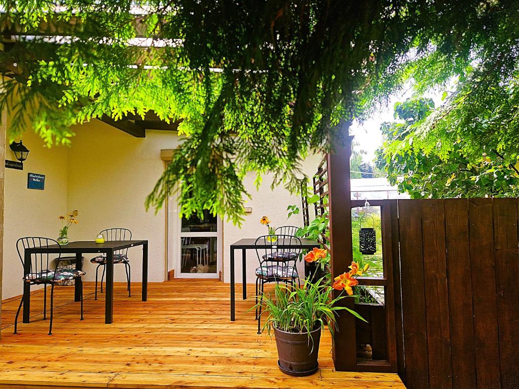 a patio with a table and chairs on a wooden deck at Rozbrykany Muflon in Witoszów Dolny