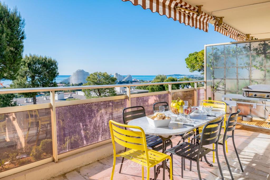 un patio avec une table et des chaises sur un balcon dans l'établissement Montfleuri, à Villeneuve-Loubet
