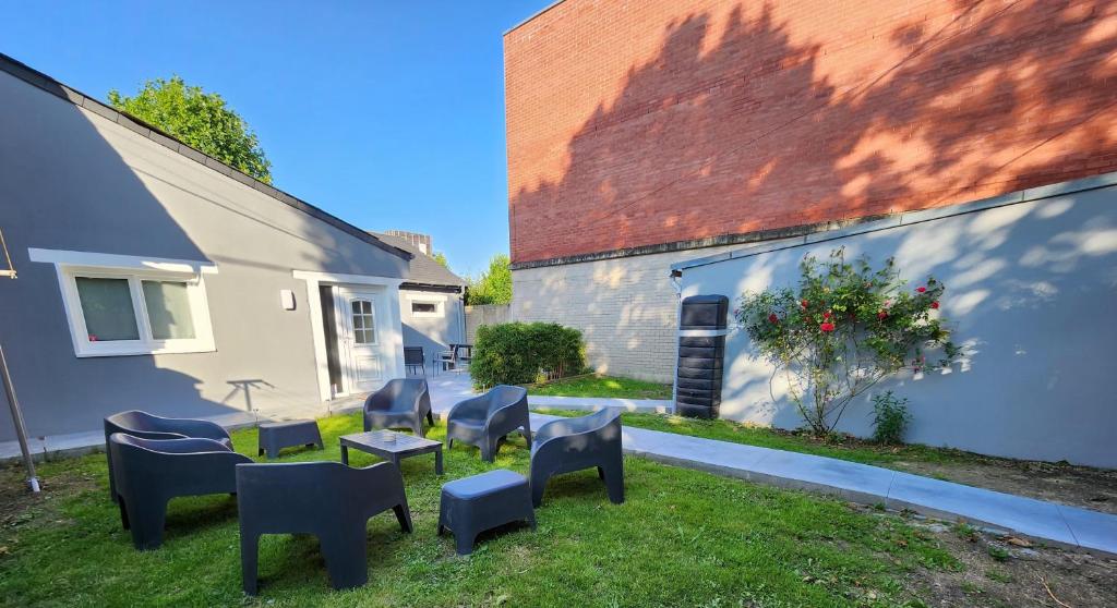 une cour avec des chaises et des tables ainsi qu'un bâtiment dans l'établissement Gite De La Borre Becque, à Merville