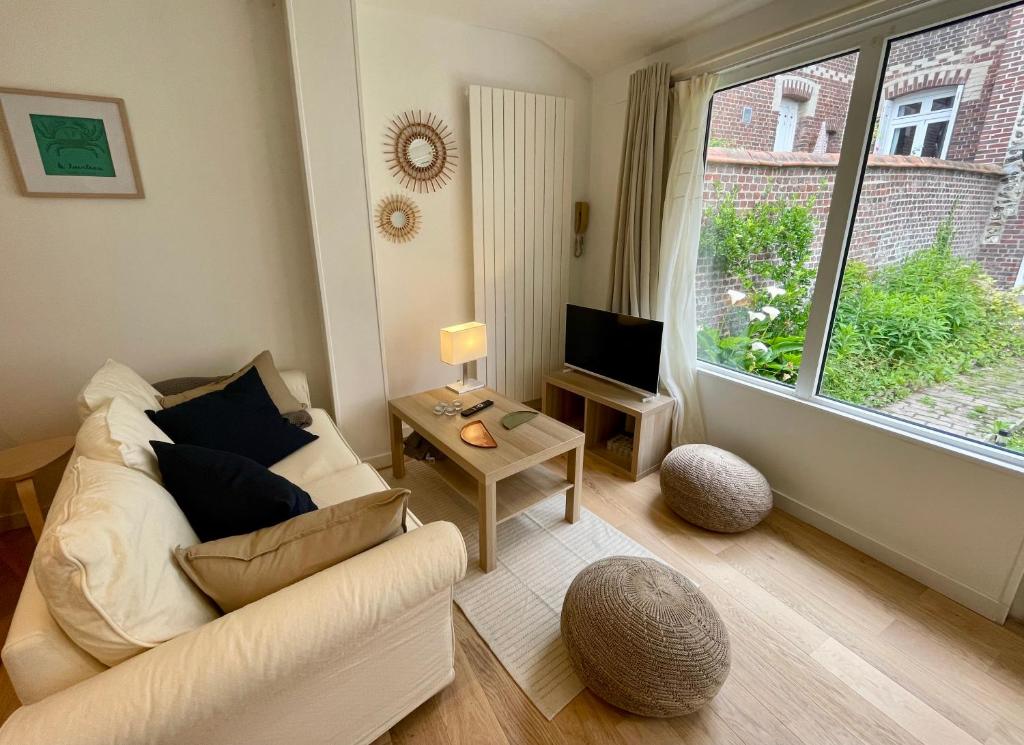 a living room with a couch and a large window at Le Refuge Marin in Dieppe