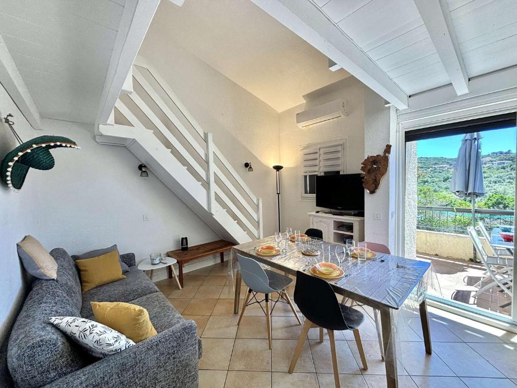 - un salon avec un canapé et une table à manger dans l'établissement Appartement 105 résidence Terra Bella 1 Porticcio, à Porticcio
