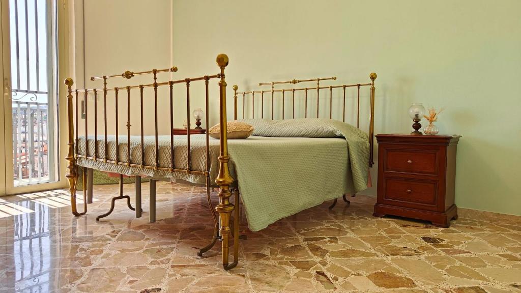 a bedroom with a bed and a wooden night stand at Al Pianotto, appartamento vintage ad Avola, vista Mare in Avola