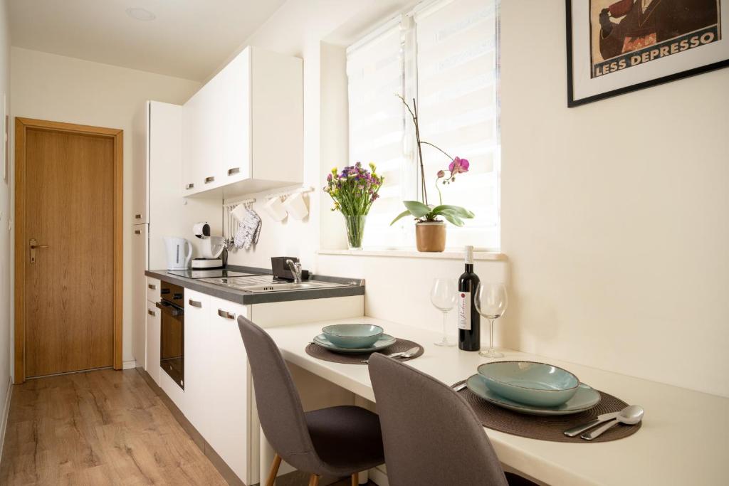 a kitchen with a table and chairs in a kitchen at Apartman Margareta in Matulji