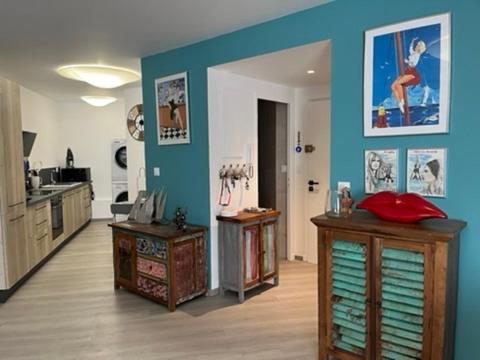 Il comprend un salon avec des murs bleus et une cuisine. dans l'établissement T2! 3 ou 4 personnes centre ville neuf avec garage, à Sanary-sur-Mer