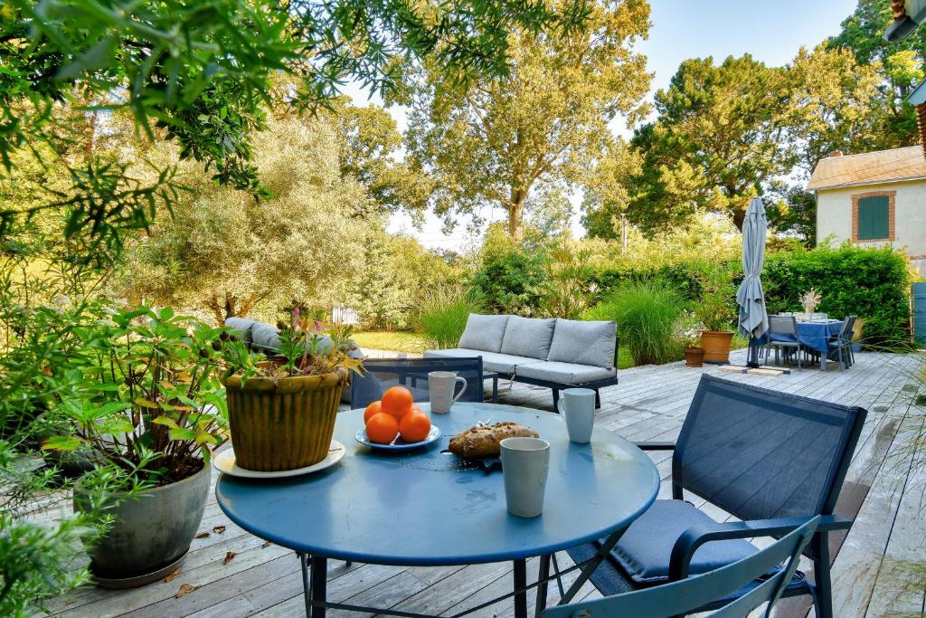 - une table bleue avec des fruits sur une terrasse dans l'établissement Villa traditionnelle pour 8 - 550m de la plage, à Noirmoutier-en-l'lle