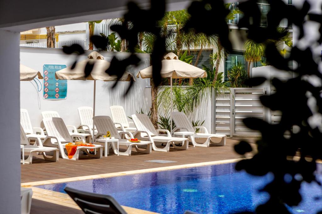 un groupe de chaises assises à côté d'une piscine dans l'établissement Milea Hotel, à Ayia Napa