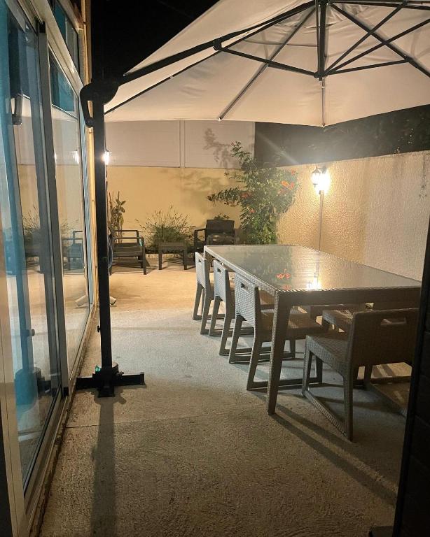 - une table et des chaises sous un parasol sur la terrasse dans l'établissement Residence du Grand Large, à Marseillan