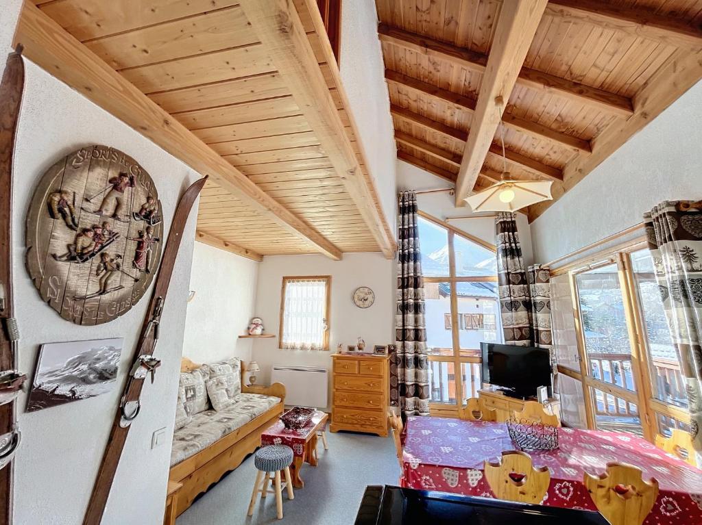 un salon avec un canapé et une télévision dans l'établissement Appartement 6 personnes Valloire, à Valloire