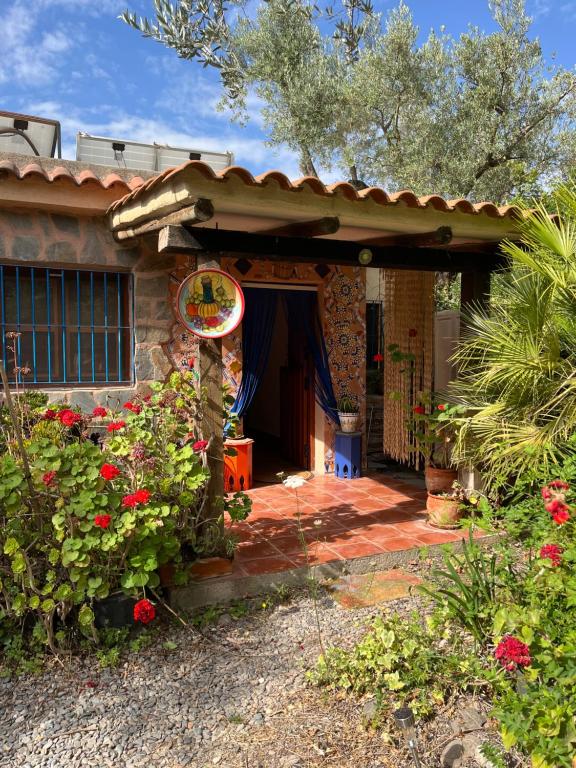 a house with a porch with flowers in front of it at Casa Aziza , le charme andalou in Lanjarón