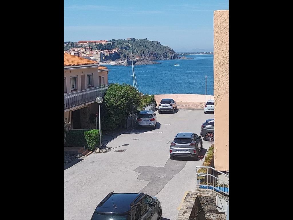 - une vue sur une rue avec des voitures garées sur la plage dans l'établissement Les Batteries 1, à Collioure