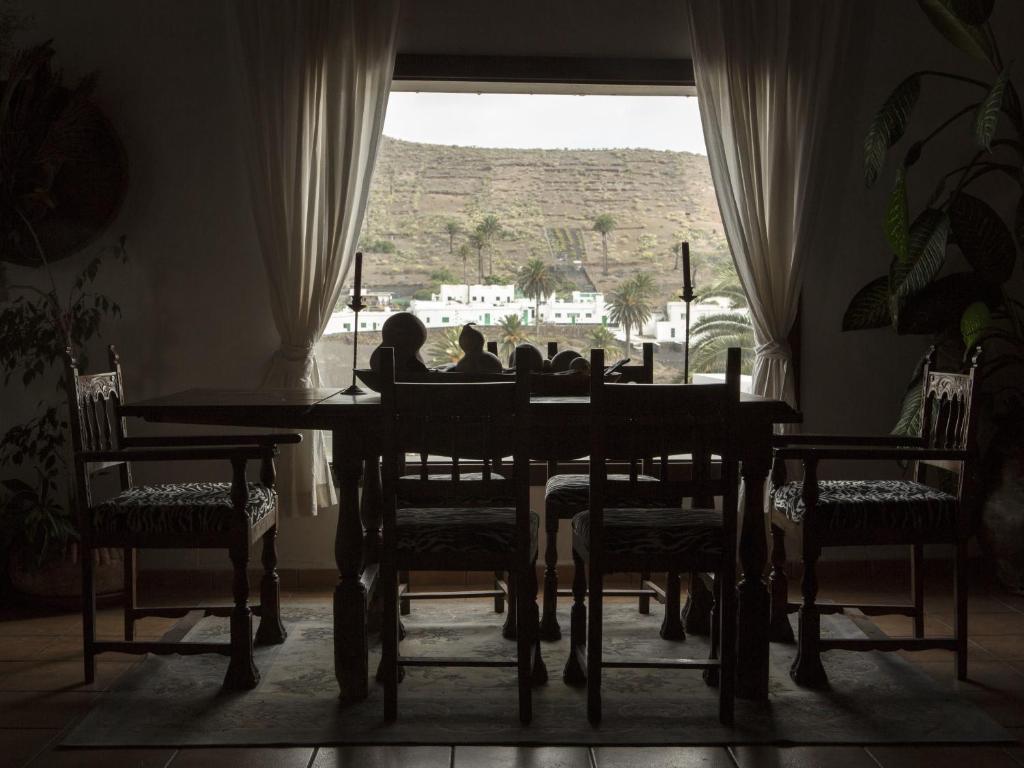 a group of people sitting at a table in a room with a window at Villa Rural Gloria´s in Haría