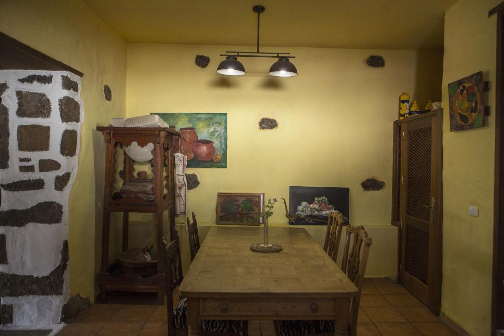 a dining room with a wooden table in a room at Villa Rural Gloria´s in Haría