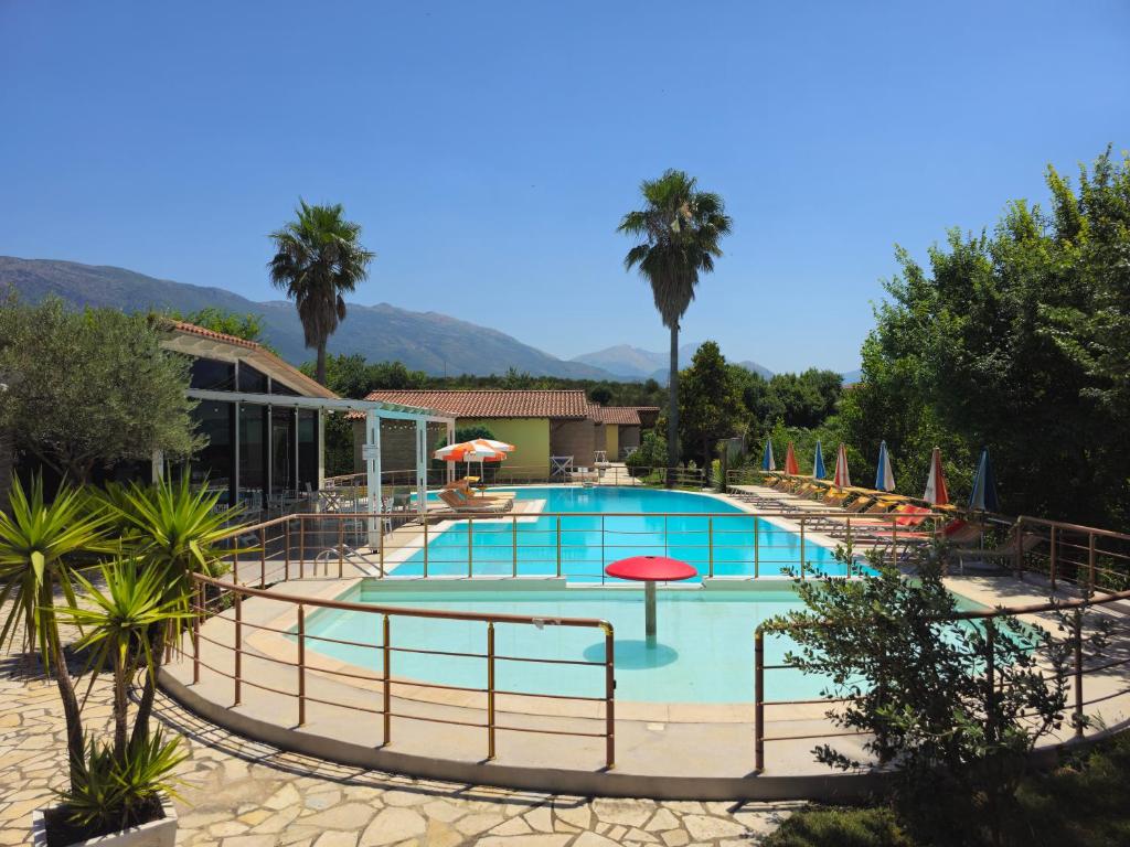 a pool with chairs and umbrellas at a resort at Resort Te Zagolli in Orikum
