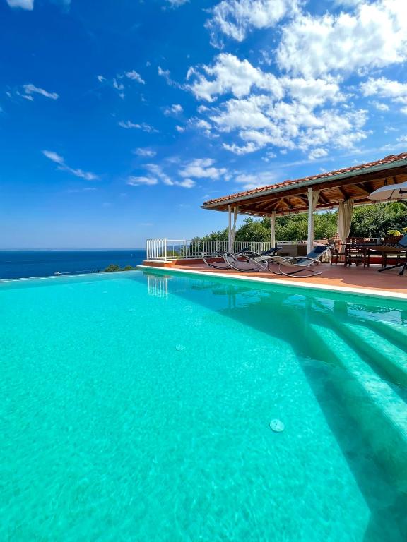 a swimming pool with a view of the ocean at VILLA LOVRAN - 150 m to the beach - infinity pool - incredible sea view - fitness gym in Lovran