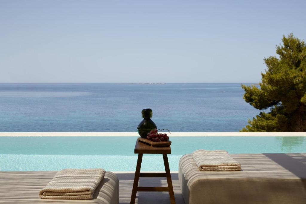 a table with a bowl of fruit next to a pool at the Wildt - Exclusive Coastal Living in Argostoli