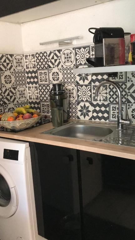 un comptoir de cuisine avec un évier et un micro-ondes dans l'établissement 15mn à pied commerces et plage, à Sanary-sur-Mer