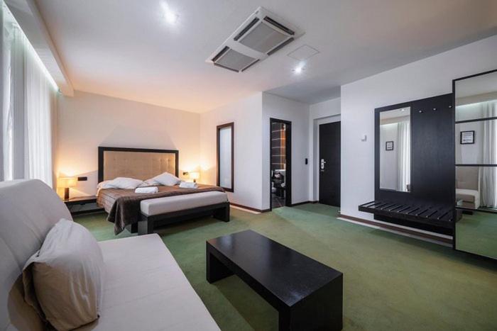 a hotel room with a bed and a coffee table at Hotel Astory Plzeň in Plzeň