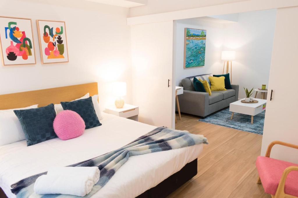 a bedroom with a bed and a living room at Charming One-Bedroom Apartment in Northbridge in Perth
