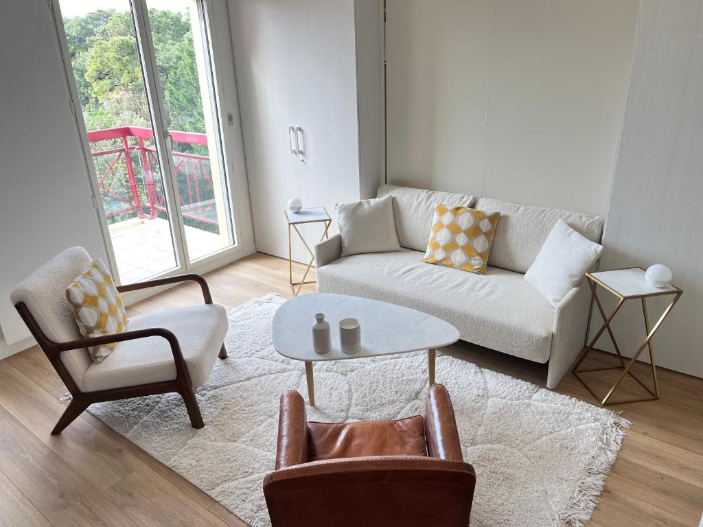 un salon avec un canapé, des chaises et une table dans l'établissement Calme et Vue - Plage 150m - Quartier Lajarrige -, à La Baule