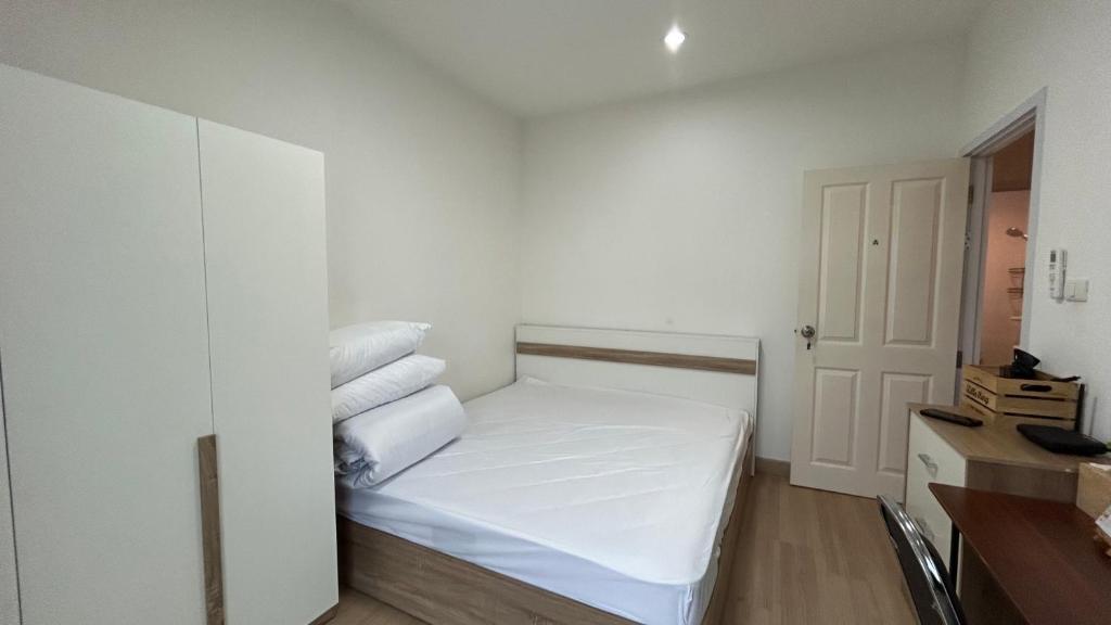 a small white room with a bed with towels on it at ไนซ์สเตย์ เฮาส์ แอทคลองสาม รังสิต คลองหลวง ปทุมธานี Nice Stay House at Khlong Sam - Rangsit - Khlong Luang - Phathumthani Self Check-in เช็คอินด้วยตนเอง in Ban Talat Rangsit