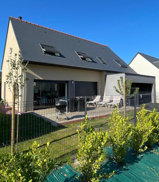 une maison avec une clôture devant dans l'établissement Maison 5 chambres sortie saint malo, à Saint-Méloir-des-Ondes