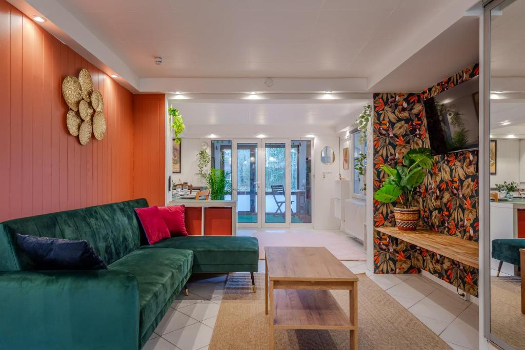 un salon avec un canapé vert et une table dans l'établissement L'Oasis - Disney 10min - Paris - Vallée Village - Parking, à Chessy