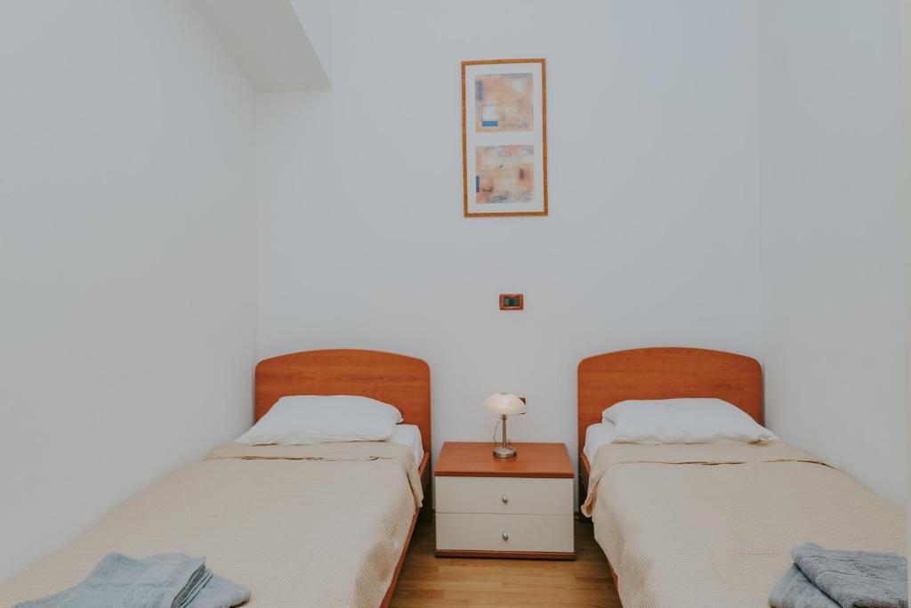 dwa łóżka siedzące obok siebie w pokoju w obiekcie Villa Danex w mieście Umag