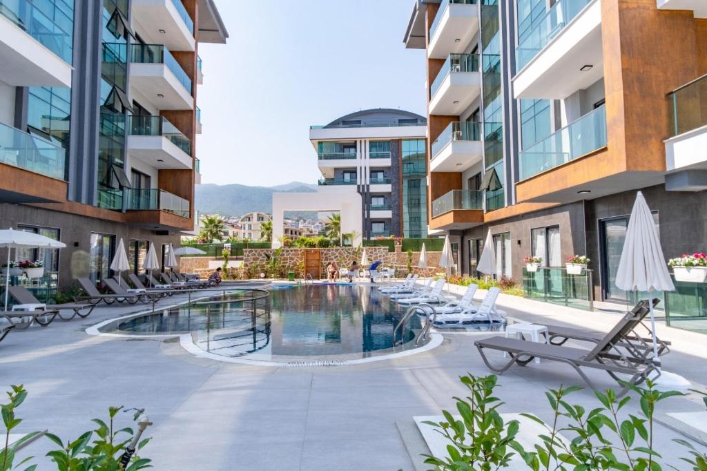 a pool in the middle of a building with chairs at Silence Garden Suite bir yatak odalı daire in Alanya