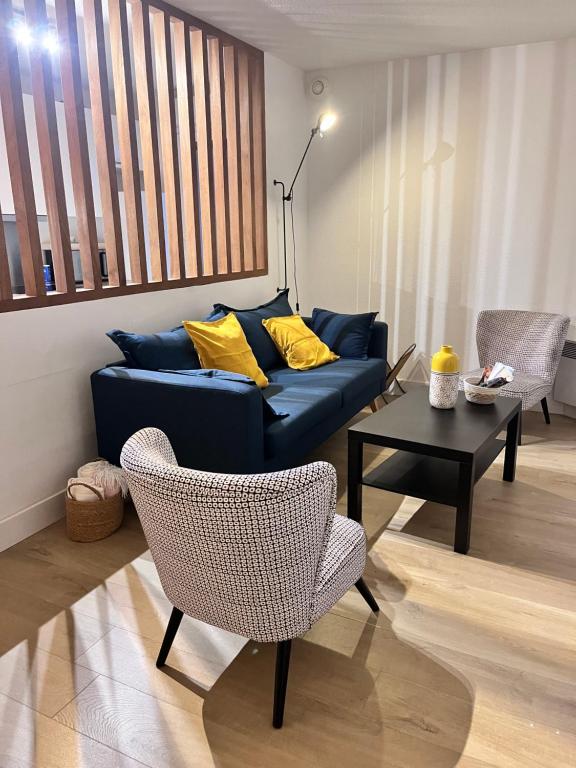 un salon avec un canapé bleu et une table dans l'établissement Appartement T3 proche remparts, à Avignon