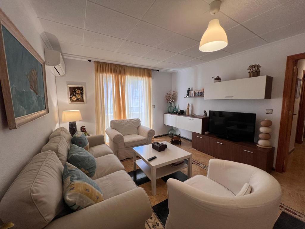 a living room with a man laying on a couch at Impecable piso a 300 mt del mar! in Puerto de Mazarrón