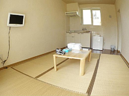 a room with a table and a tv on the wall at Cha Villa in Zamami