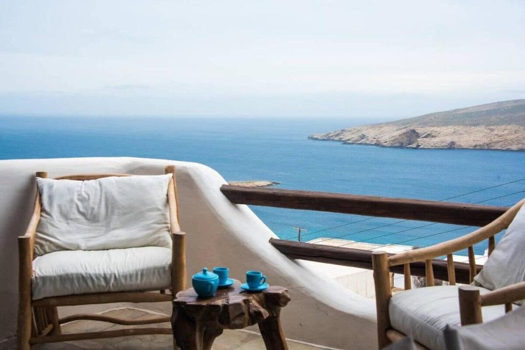 uma varanda com cadeiras e vista para o oceano em Apt with Amazing Balcony View of Mykonos em Agios Sostis Mykonos