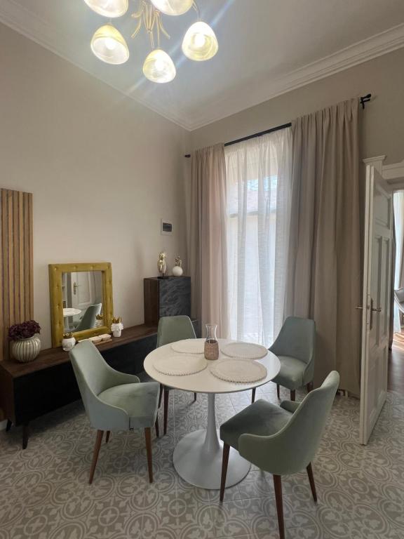 un soggiorno con tavolo e sedie di La Strada Central Apartament a Oradea