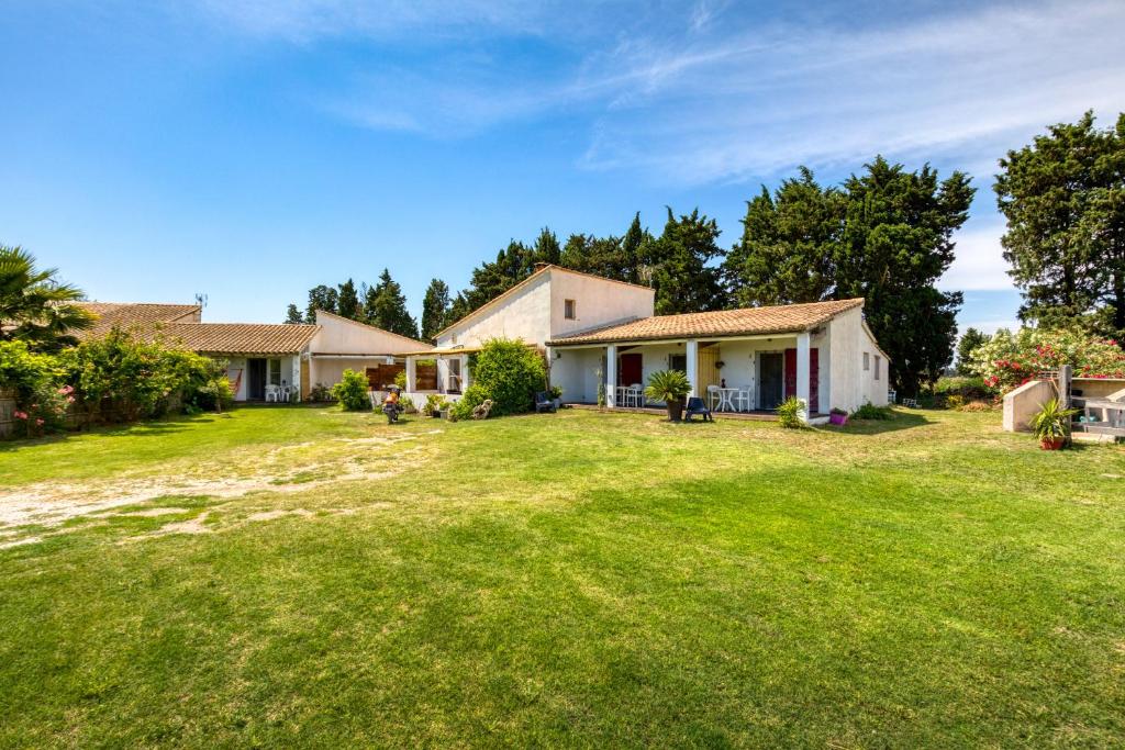 une maison avec une grande cour dans l'établissement Mas des Cypres - Mazet 5, à Saintes-Maries-de-la-Mer