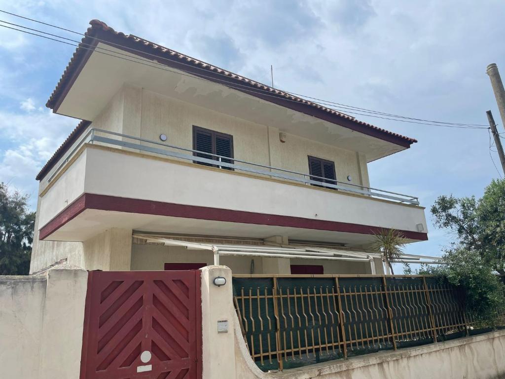 uma casa com um portão na frente em Sunset Villa em Torre Lapillo